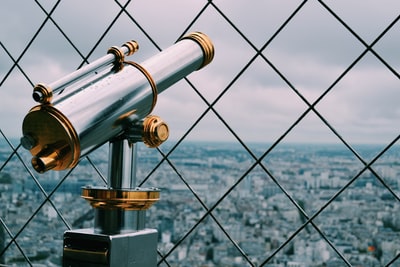 Cyclone fence at the back of the gray and gold telescope
